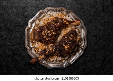 Grilled lamb Lamb shoulder ,on durum wheat or Freekeh or farik  with rice and nuts top view on a dinner table.