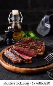 Grilled marbled rib eye steak with green chimichurri sauce. Roasted barbecued beef meat