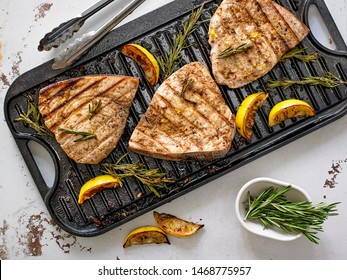 Grilled Marinated Swordfish Steaks with Lemon and Rosemary on cast iron grilling pan.