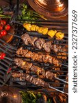  Grilled meat. Shish kebab.  Eastern fast food. Mix kebab meat, chicken, lamb, beef. Grilled meat skewers on rustic wooden table. Restaurant menu, advertisement, banner, poster