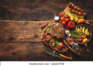 Grilled meat and vegetables on rustic wooden table - Shutterstock ID 626267978