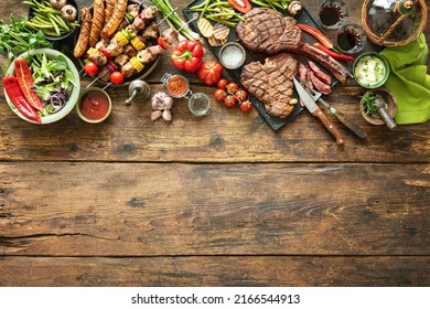 Grilled Meats And Vegetables On Rustic Timber Picnic Table