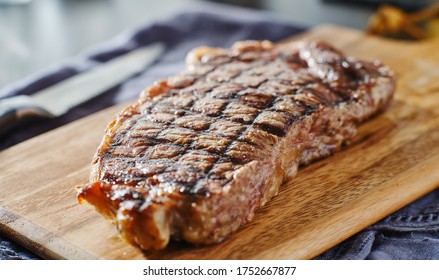 Grilled New York Strip Steak Resting On Wooden Cutting Board