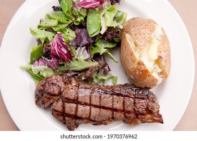 Grilled New York Strip Steak With Salad And Baked Potato