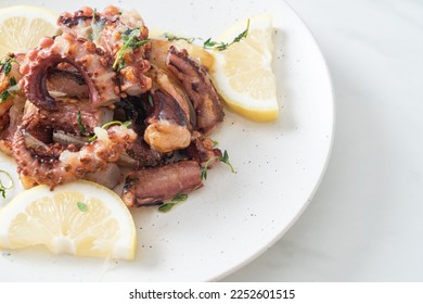 grilled octopus or squid with butter lemon sauce and thyme - Shutterstock ID 2252601515