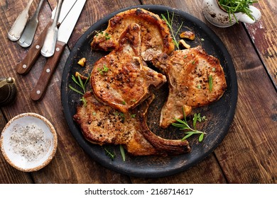 Costillas de cerdo fritas a la parrilla o a la sartén sobre el hueso con ajo y romero