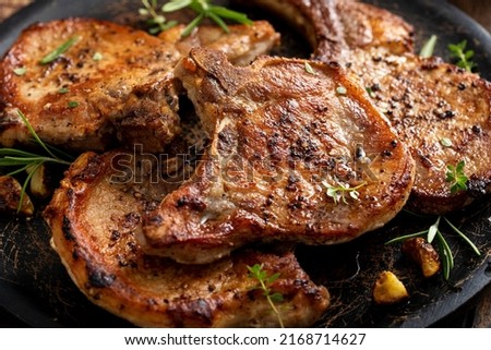 Grilled or pan fried pork chops on the bone with garlic and rosemary