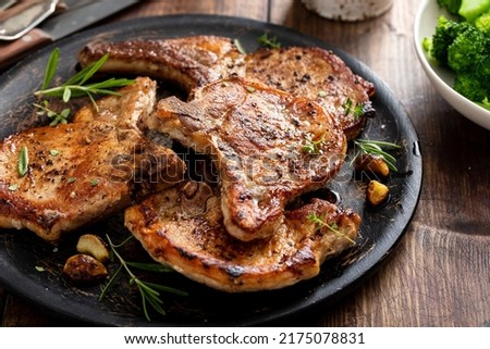 Grilled or pan fried pork chops on the bone with garlic and rosemary