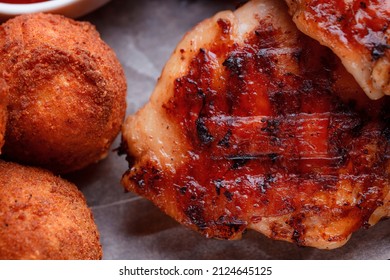 Grilled Piece Of Meat. Crispy Chicken Wings. The Texture Of The Meat Is Very Close Up. Seasoning In The Form Of Ketchup And Sprigs Of Rosemary.