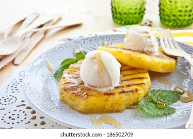 Grilled pineapple with scoops of vanilla ice cream