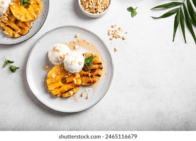 Grilled pineapples with rum honey glaze, coconut icecream and grated peanuts, tropical vegan dessert on white background, top view, copy space. - Powered by Shutterstock