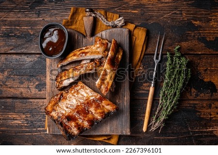 Grilled pork Baby Back spare ribs on a wooden board. Wooden background. Top view.