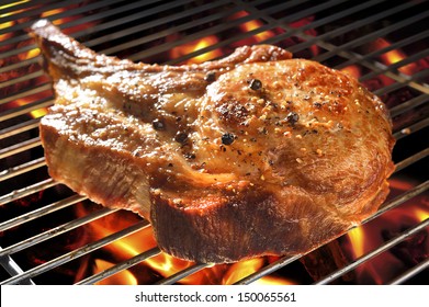 Grilled Pork Chop On Flaming Grill.