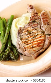 Grilled Pork Chop With Potato Mash And Fresh Asparagus.