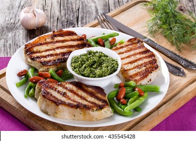 Grilled Pork Chops On A White Dish