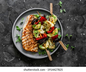 Grilled pork chops, vegetables skewers  on a dark background, top view. Delicious tapas                   
