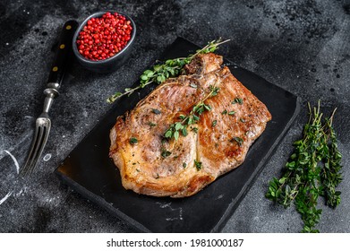 Grilled Pork Loin Steak On A Marble Board. Black Background. Top View