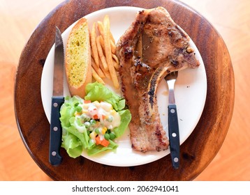 Grilled Pork Ribs Steak Served With French Fries, Toast And Salad