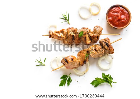 Grilled pork skewers isolated on white background, top view. Meat pork, chicken or turkey shish kebab with tomato sauce,  herbs and spices.