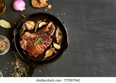 Grilled Pork Steak In Frying Pan On Black Background With Copy Space. Top View, Flat Lay Food