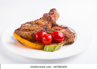 Grilled Pork Steak And Vegetables On A White