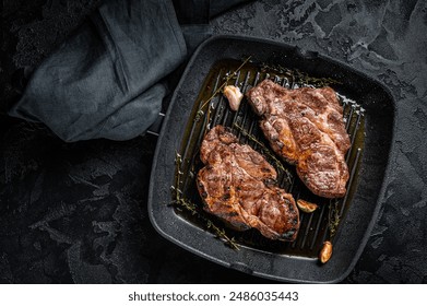 Grilled Pork steaks, neck meat on grill pan. Black background. Top view. - Powered by Shutterstock