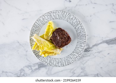 Grilled Pork Steaks With Romaine Lettuce On A White Round Plate. Horizontal Orientation 