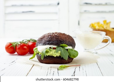 Grilled Portobello Bun Mushroom Burger. Vegan, Gluten Free, Grain Free, Healthy Veggies Hamburger With Guacamole, Fresh Vegetables, Cashew Cheese Sauce And Crispy Baked Zucchini Fries. Copy Space