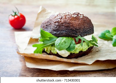 Grilled Portobello Bun Mushroom Burger. Vegan, Gluten Free, Grain Free, Healthy Veggies Hamburger With Guacamole, Fresh Vegetables And Cashew Cheese Sauce.