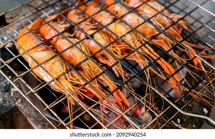 Grilled Prawn On Charcoal Grill. Giant Freshwater Prawns Grill On A Flaming Charcoal Fire. Closeup Giant River Prawn Cooking On Barbecue Grill Rack. Cooking Food For The Party. Thai Food Culture.