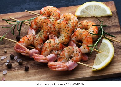 Grilled Prawns With Italian Seasonings, Salt, Pepper, Lemon And Rosemary  On A Wooden Board