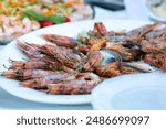 Grilled prawns served on a white plate, adding a gourmet touch to the wedding reception buffet