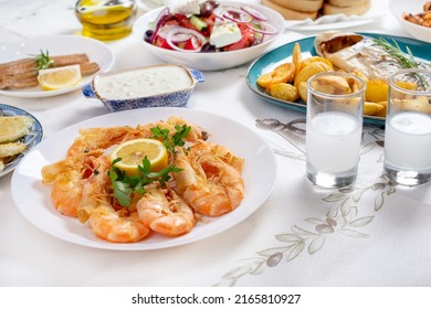 Grilled prawns or shrimps with lemon, top view. Traditional Greek tavern menu. Variety of seafood dinner. 