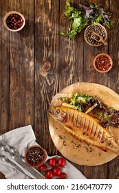 Grilled Rainbow Trout With Herbs On Wooden Background. Composition With Roasted Rainbow Trout And Ingredients. Grilled Whole Fish On Wooden Table In Rustic Style