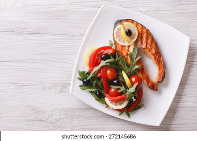 Grilled Red Fish Salmon And A Salad On A Plate. Horizontal View From Above 