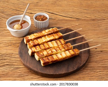 Grilled Rennet or Coalho cheese on a wooden board with sugar syrup and pepper. - Shutterstock ID 2017830038
