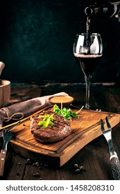 Grilled Ribeye Beef Steak With Wine, Knife And Fork On A Wooden Board. Whole Roast Piece Of Meat, Rustic Style