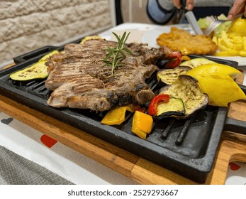 grilled ribs with vegetables and lemon on the table on a cast iron tray. High quality photo - Powered by Shutterstock