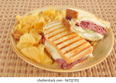 A Grilled Roast Beef And Swiss Panini With Potato Chips