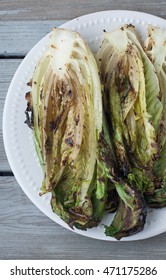 Grilled Romaine Lettuce On A White Plate , Rustic Wooden Weathered Wood Table 