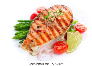grilled salmon with asparagus and cherry tomatoes on white plate