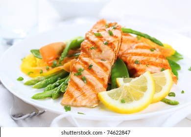 grilled salmon with asparagus, pea, yellow peppers, carrots and spring onions on white plate - Powered by Shutterstock