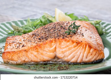 Grilled salmon fillet with pepper on a green plate