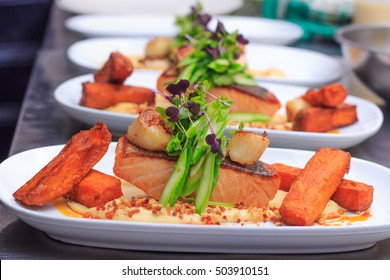 Grilled Salmon Fillet With Seared Scallops, Asparagus, Cauliflower Puree, Sweet Potato Chips, Bacon Crumble And Baby Herbs