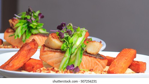 Grilled Salmon Fillet With Seared Scallops, Asparagus, Cauliflower Puree, Sweet Potato Chips, Bacon Crumble And Baby Herbs