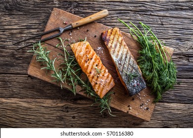 Grilled salmon fillets with salt pepper and herb decoration.