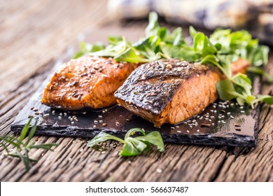 Grilled Salmon Fillets Sesame Seeds Herb Decoration And Black Slate Board On Old Oak Table.