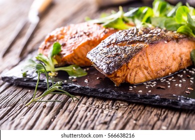 Grilled Salmon Fillets Sesame Seeds Herb Decoration And Black Slate Board On Old Oak Table.