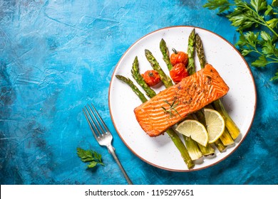 Grilled Salmon Fish Fillet With Asparagus. Top View On Blue Stone Table.