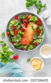 Grilled salmon fish fillet and fresh green leafy vegetable salad with tomatoes, red onion and broccoli. Healthy food. Ketogenic lunch. Top view - Shutterstock ID 2207186433
